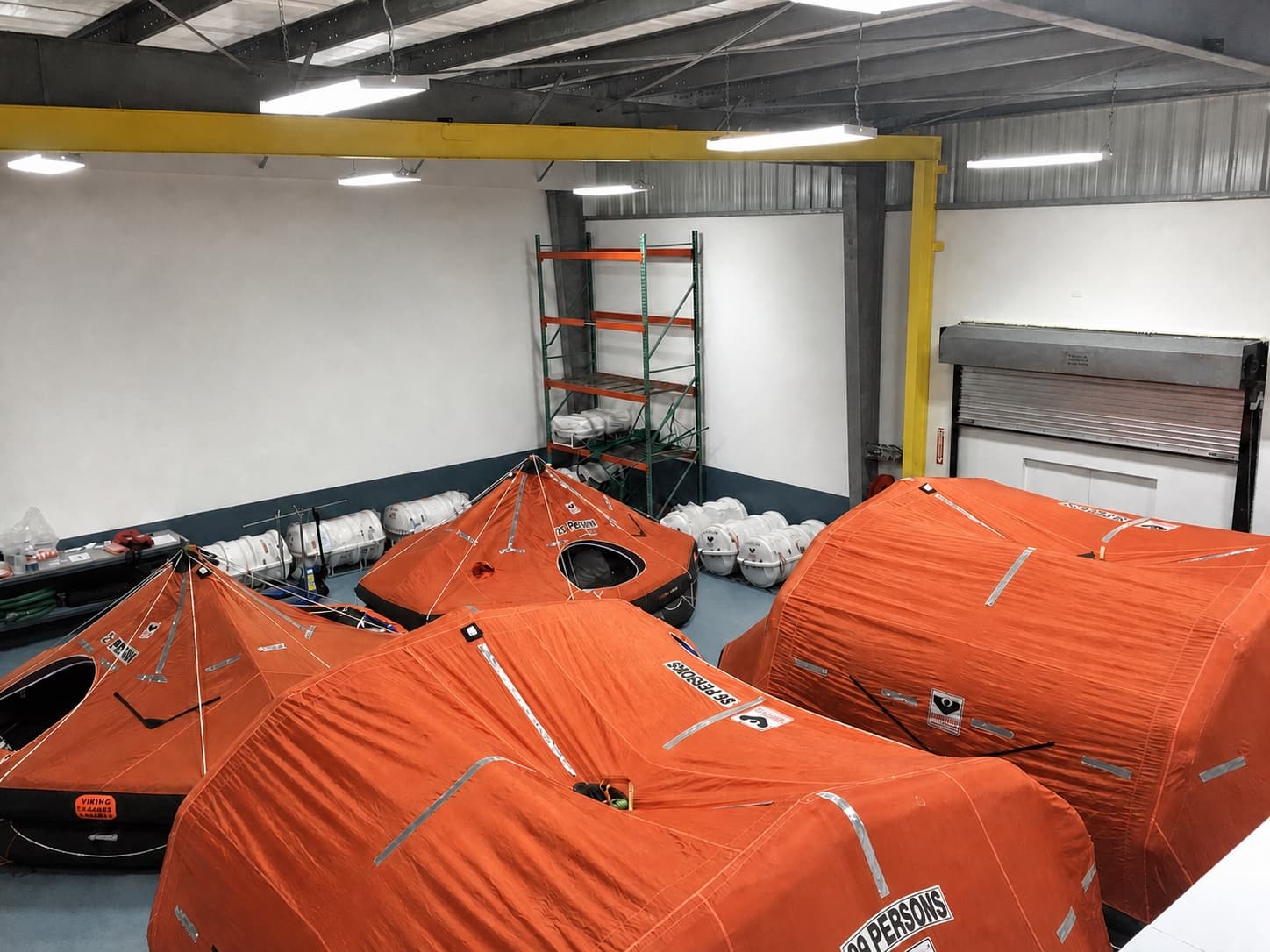 Open liferafts arranged for service inside The Safety Pelican workshop