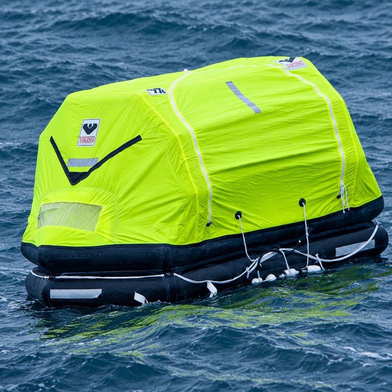 Yellow VIKING liferaft afloat on open water