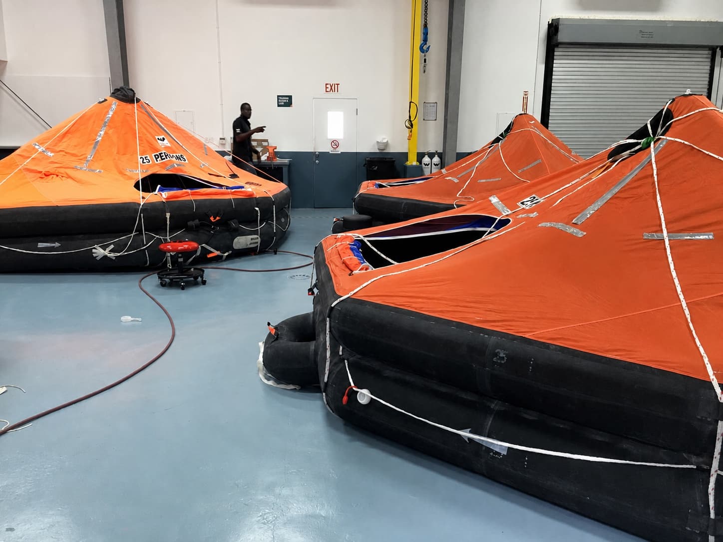 Technician servicing open liferafts inside The Safety Pelican workshop