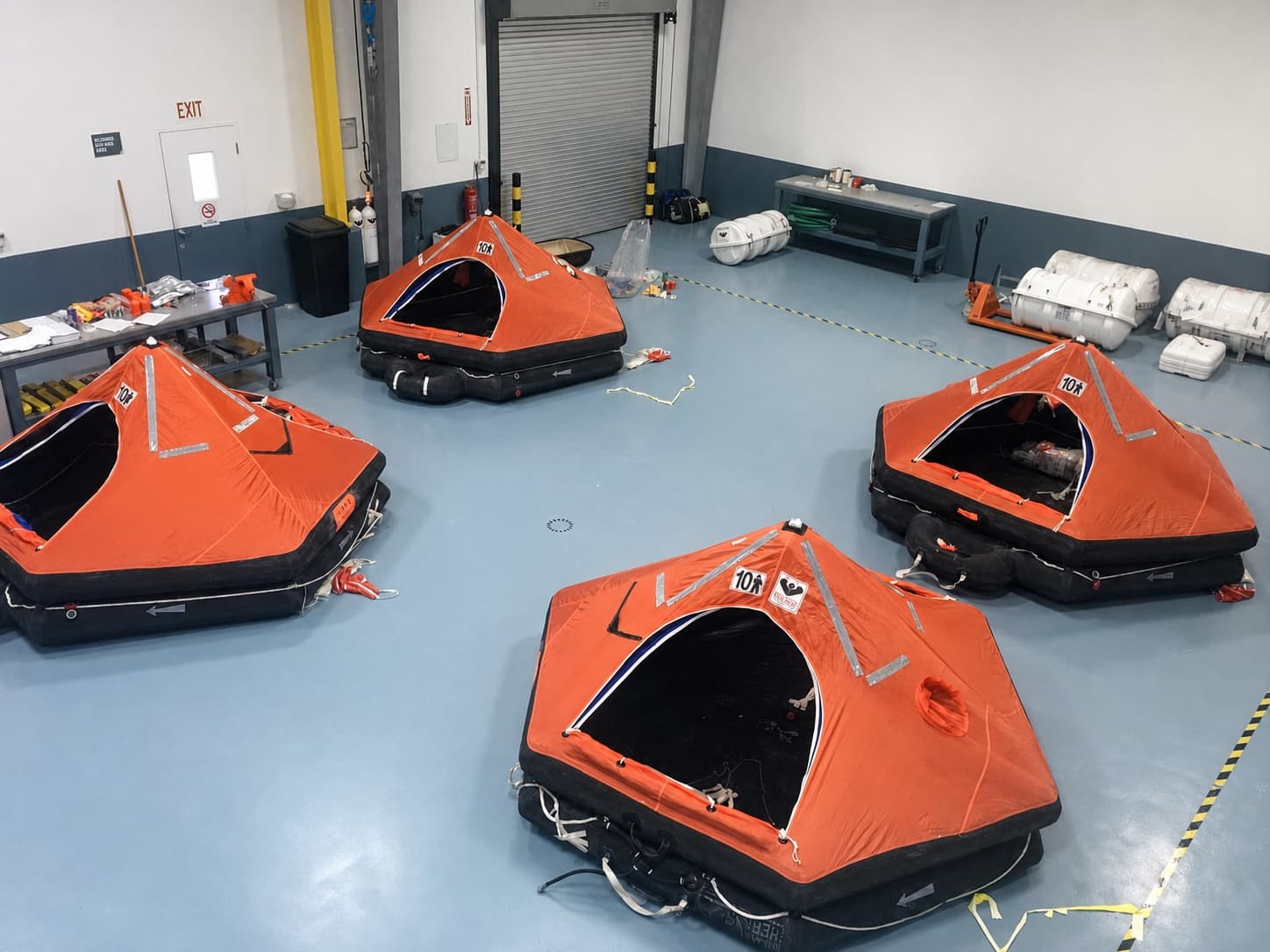 Multiple inflated liferafts arranged for service inside The Safety Pelican workshop
